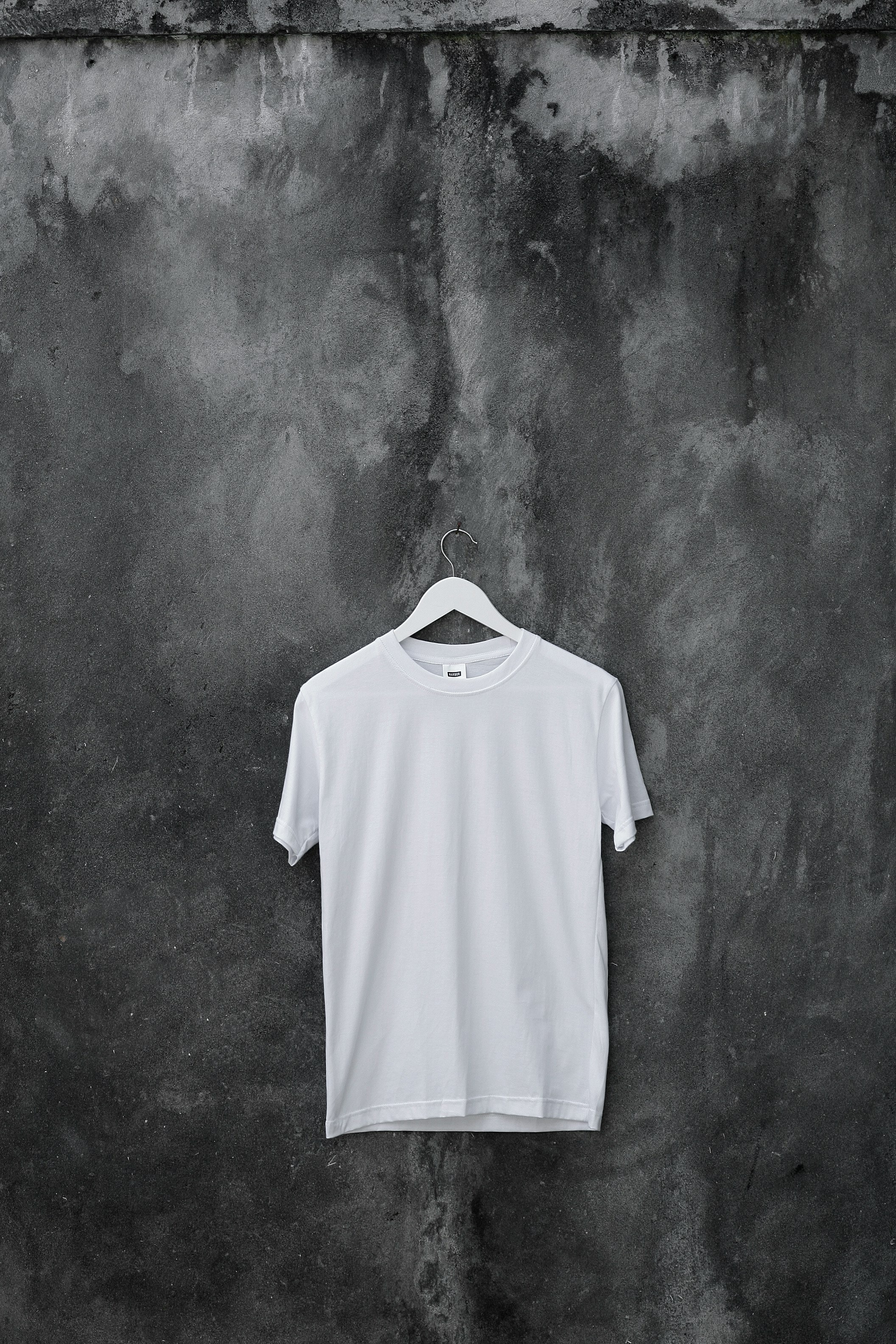 Camiseta colgando de una pared gris